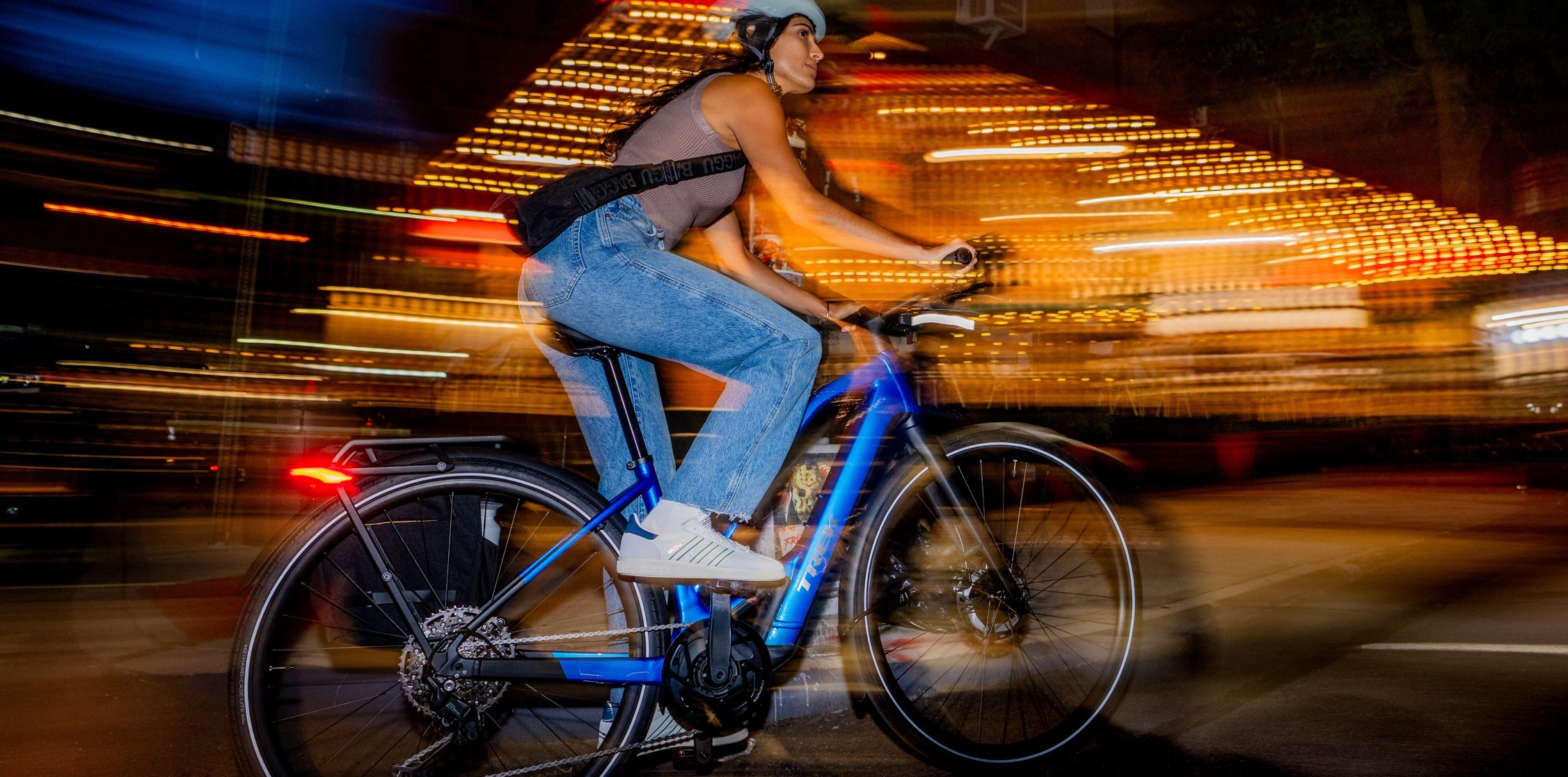 Person riding a bicycle at night with blurred lights in the background
